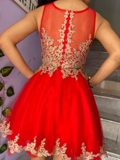 Vestido rojo con detalles bordados en oro en la espalda y el bajo de la falda.