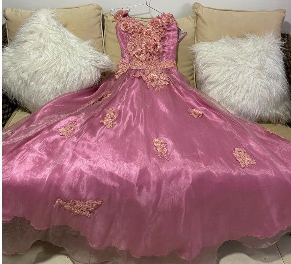 Vestido de gala rosa con adornos florales.