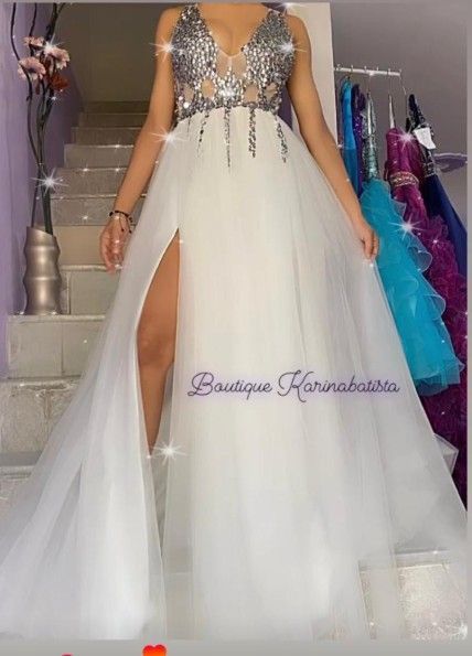 Mujer con vestido blanco de abertura alta y corpiño de lentejuelas. Ambiente de boutique.