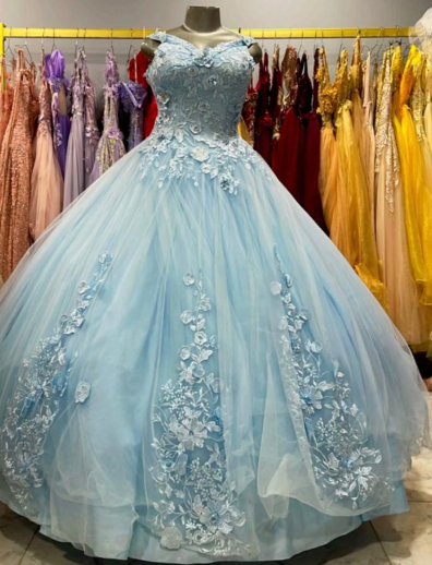 Vestido de gala azul claro con apliques florales expuesto en una tienda de vestidos.