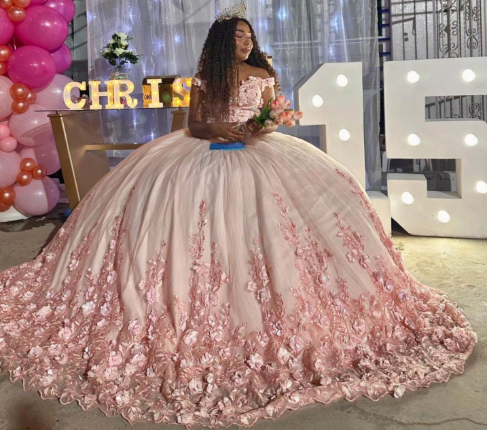 Adolescente con un vestido de gala rosa estampado de flores, sosteniendo un ramo. Celebrando una quinceañera con globos
