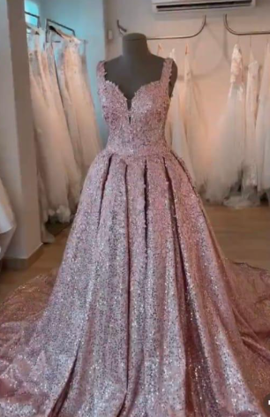 Vestido de gala rosa con lentejuelas sobre un maniquí en una tienda de novias.