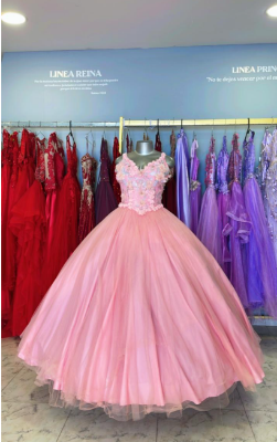 Vestido de gala rosa sobre un maniquí, expuesto en una tienda de vestidos junto a otros vestidos coloridos colgados