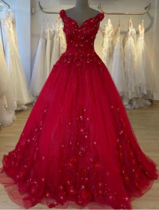 Vestido de gala rojo con adornos florales y escote barco en una tienda de novias.