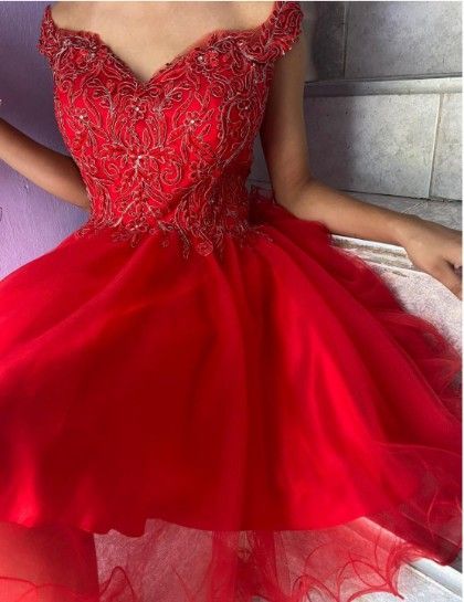 Mujer con un vestido rojo de hombros descubiertos con intrincados detalles en el corpiño; falda de tul.