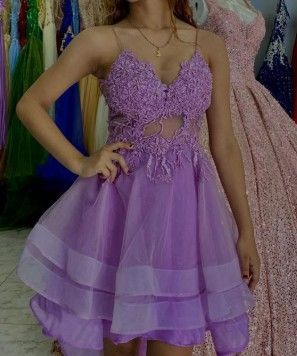 Mujer con un vestido lavanda con corpiño de cuentas, de pie en una tienda de vestidos.