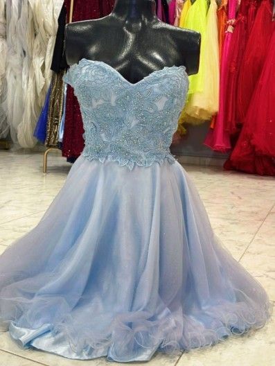 Vestido de gala azul claro sin tirantes sobre un maniquí; corpiño con detalles, falda acampanada.