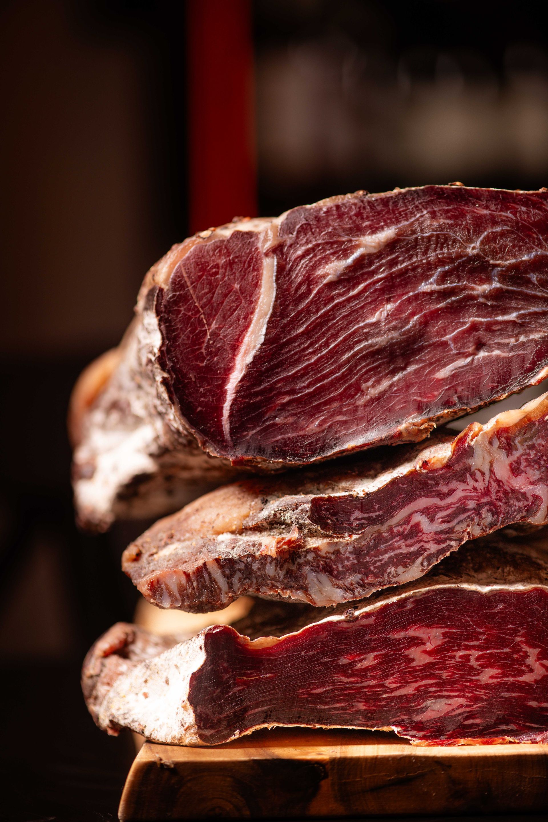 Primo piano di una pila di carne su un tagliere di legno.