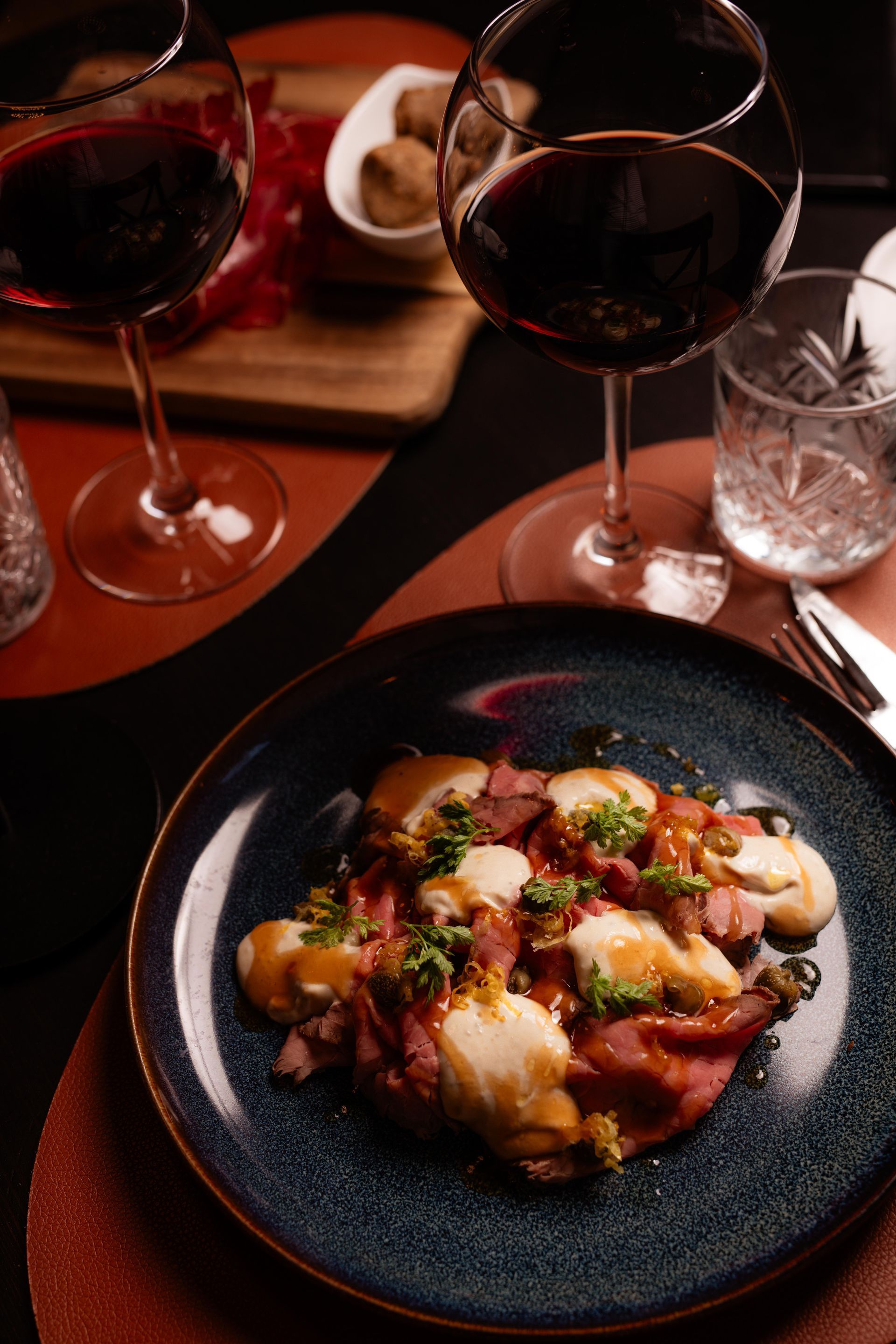 Un piatto di cibo e due bicchieri di vino su un tavolo.
