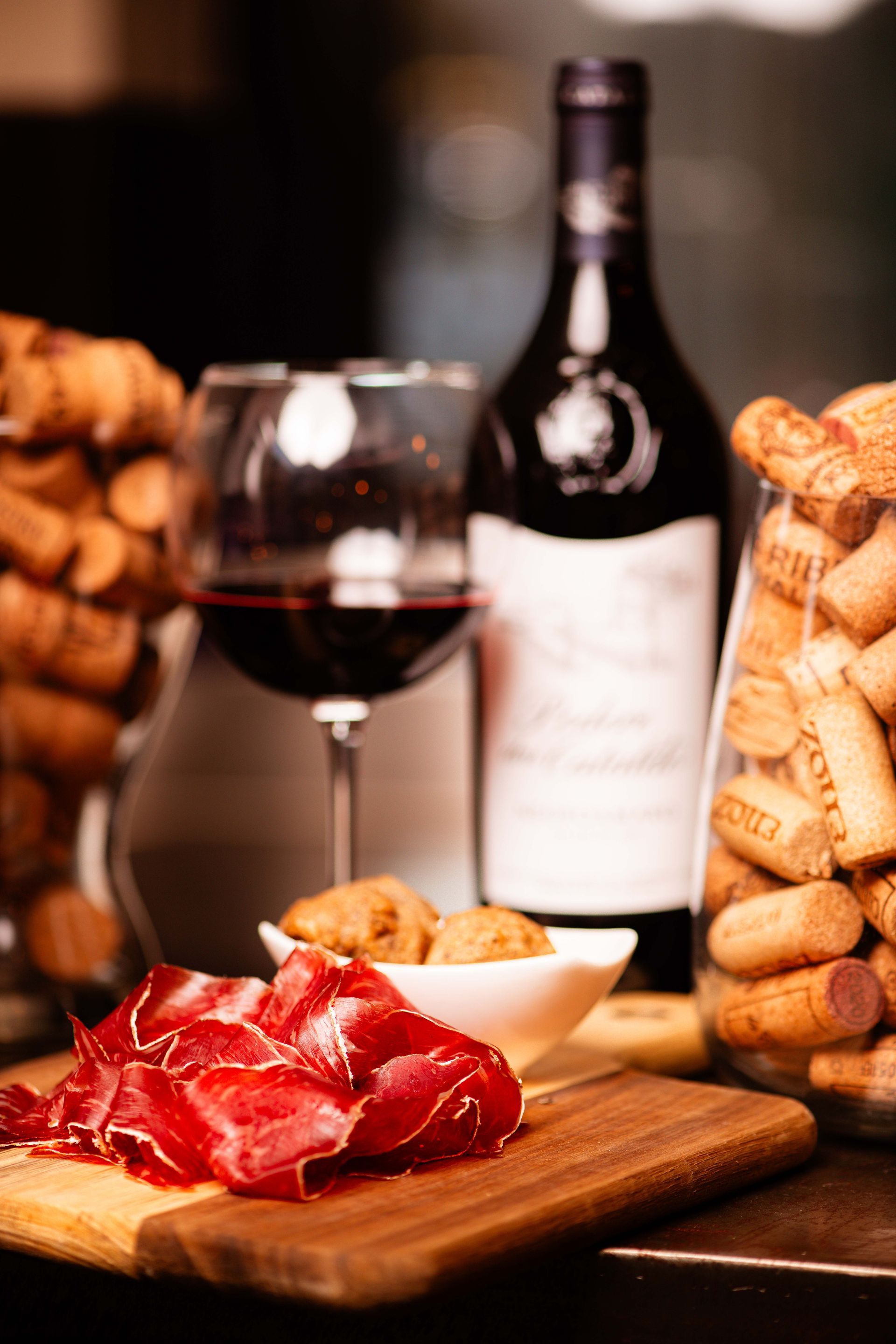 Calice e tagliere del percorso di degustazione vini a Monza offerto dall'enoteca.