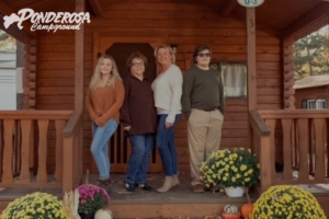 A group of people standing in front of a ponderosa cabin