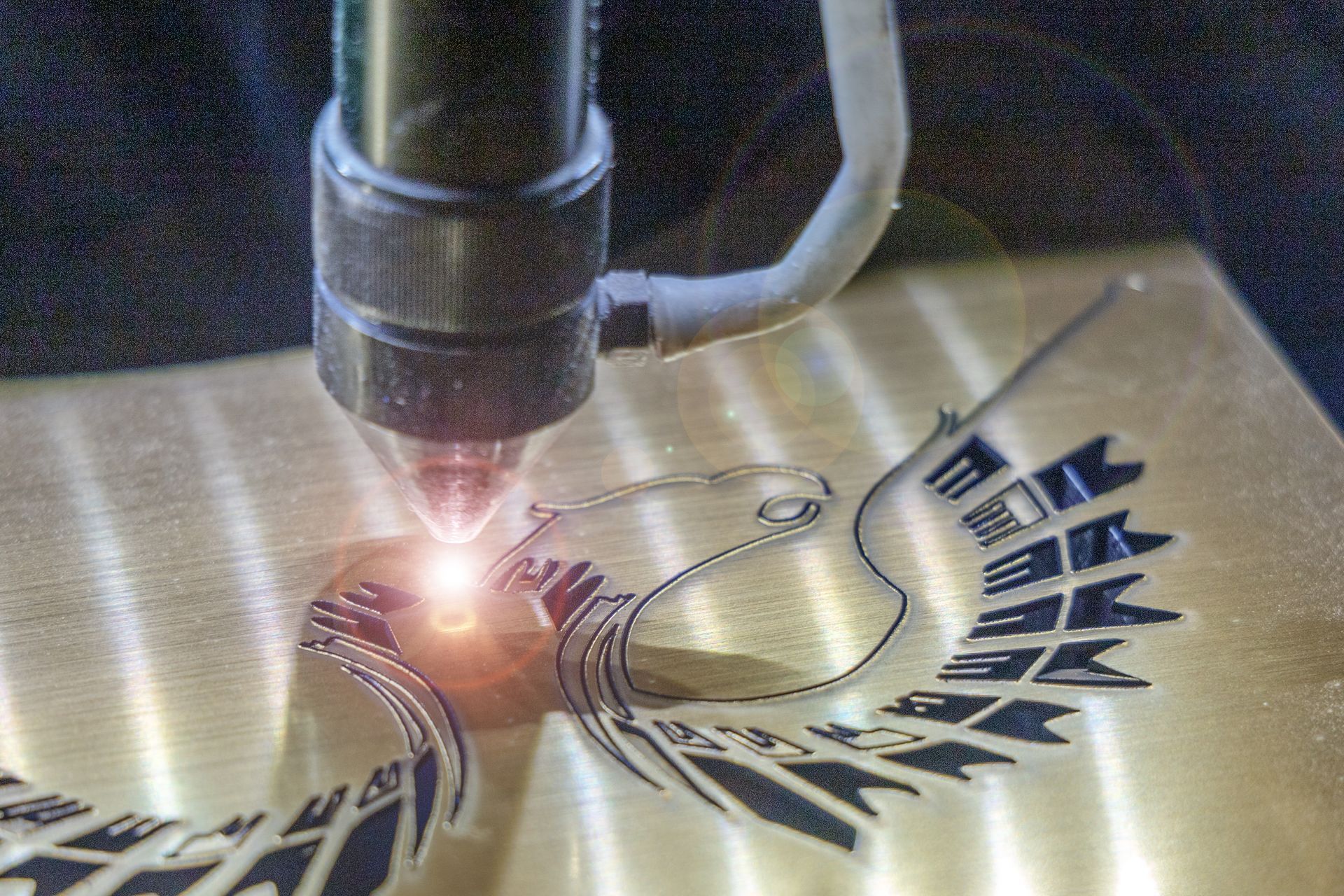 A machine is cutting a picture of an eagle on a piece of metal.