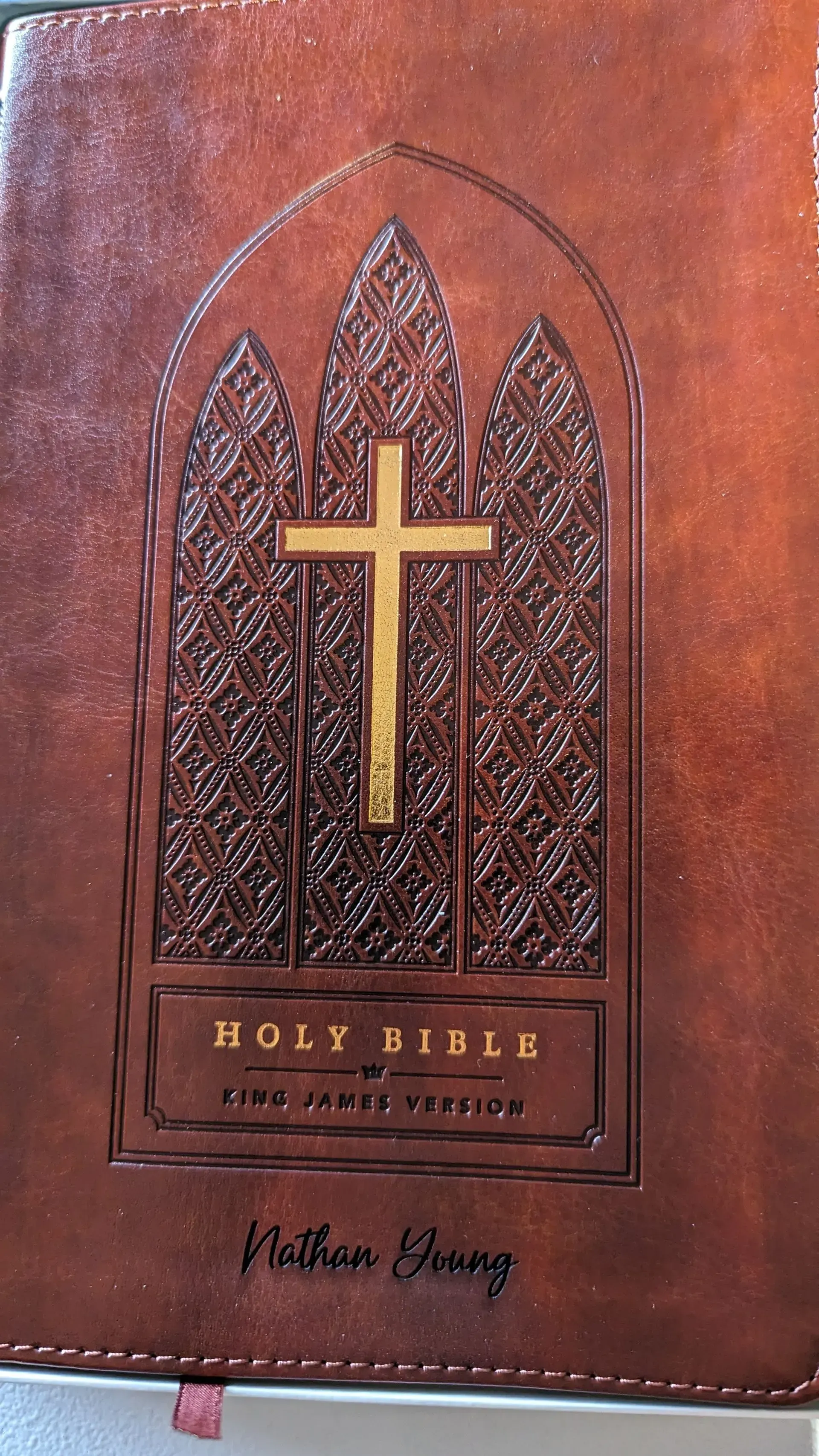 A brown leather bible with a cross on the cover.