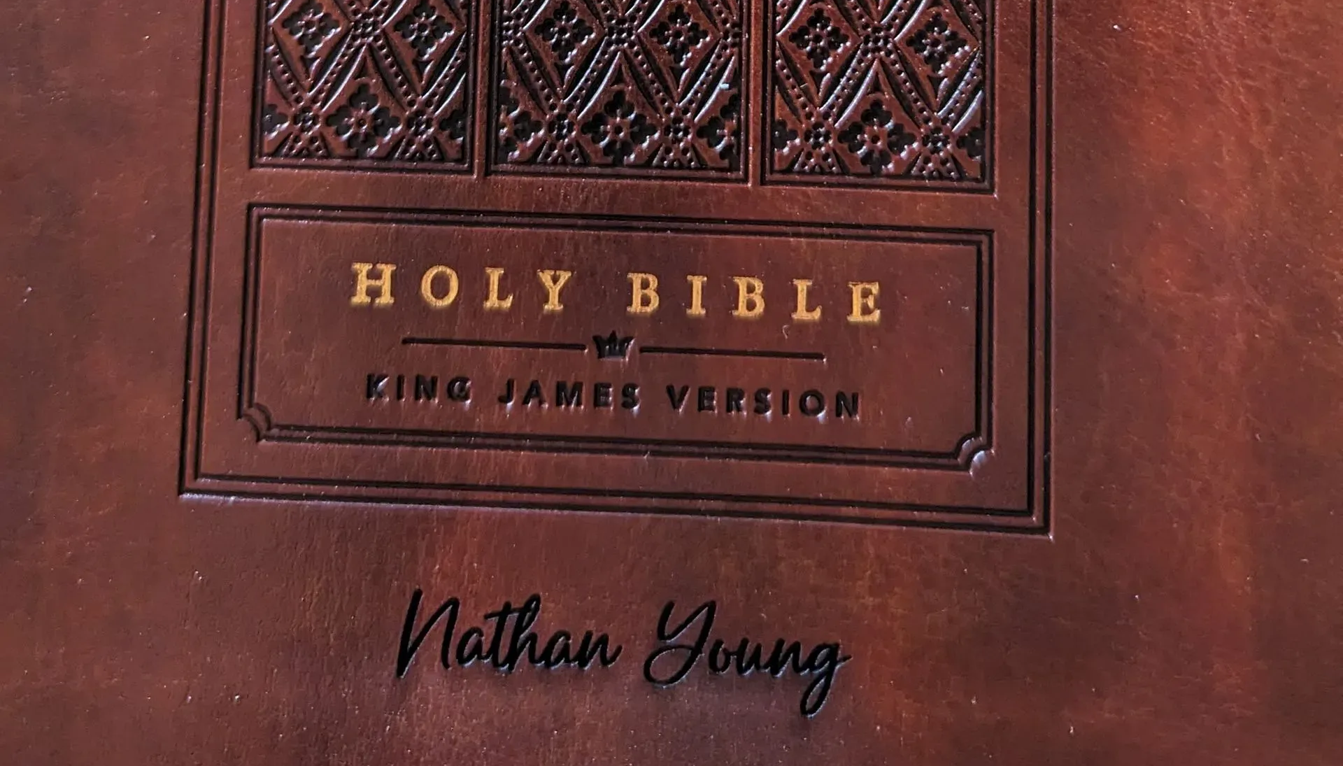 Brown leather Bible cover with embossed text: 