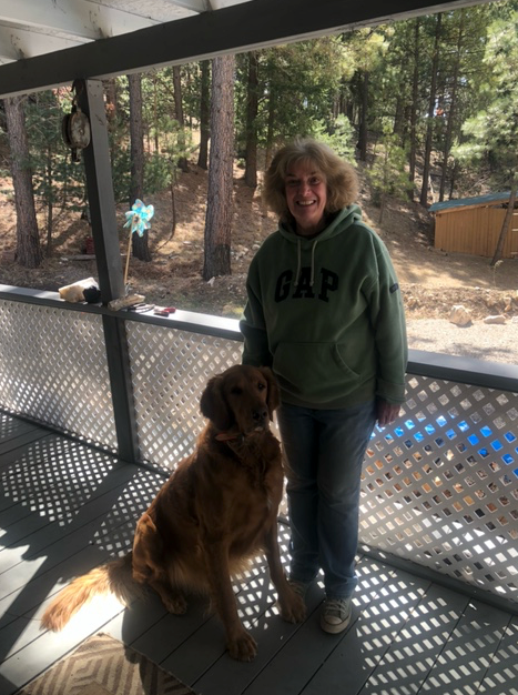 A woman wearing a gap hoodie stands next to a dog