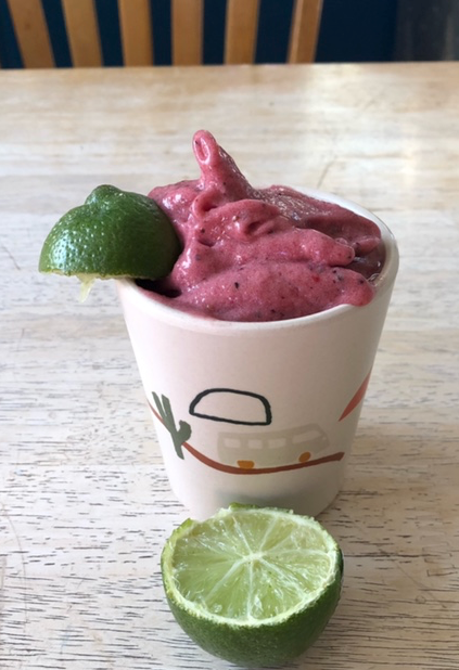 A cup of smoothie with a lime slice on top