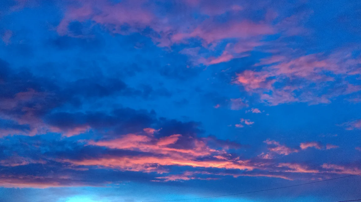 A blue sky with pink clouds at sunset