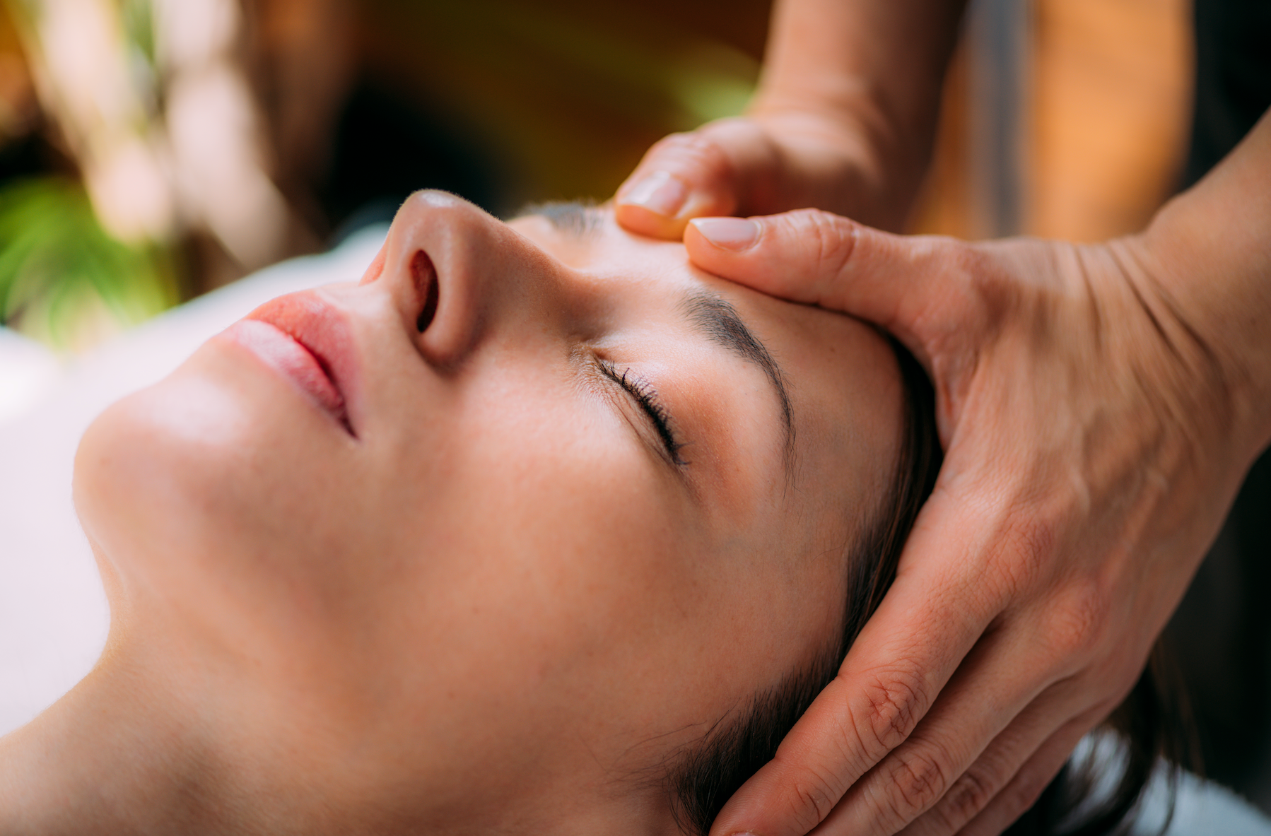 A woman is getting a head massage at a spa.