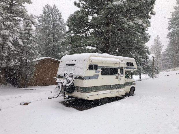 A white rv is parked in the snow.