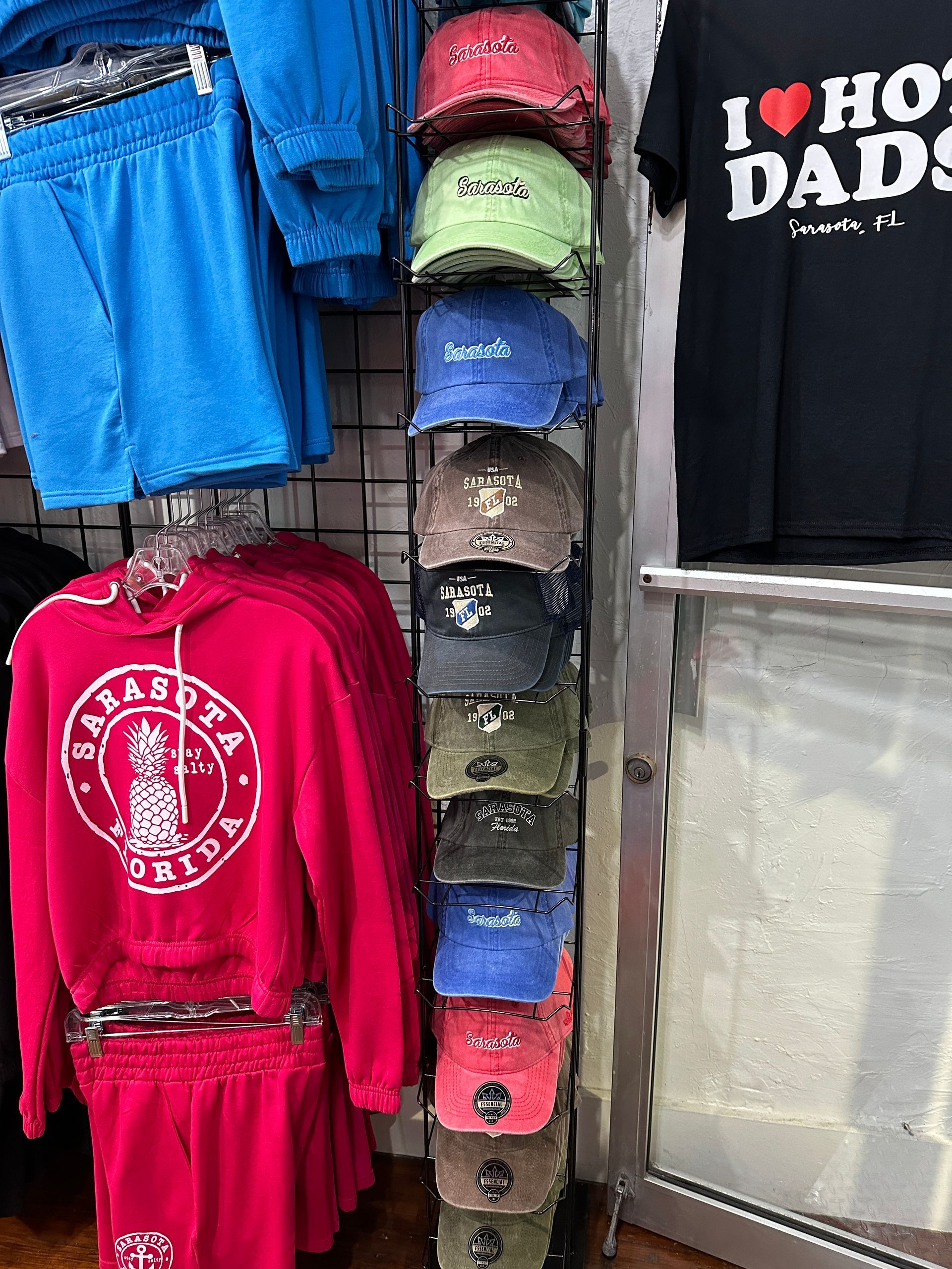 Clothing rack with various hats, hoodies, shorts, and a 