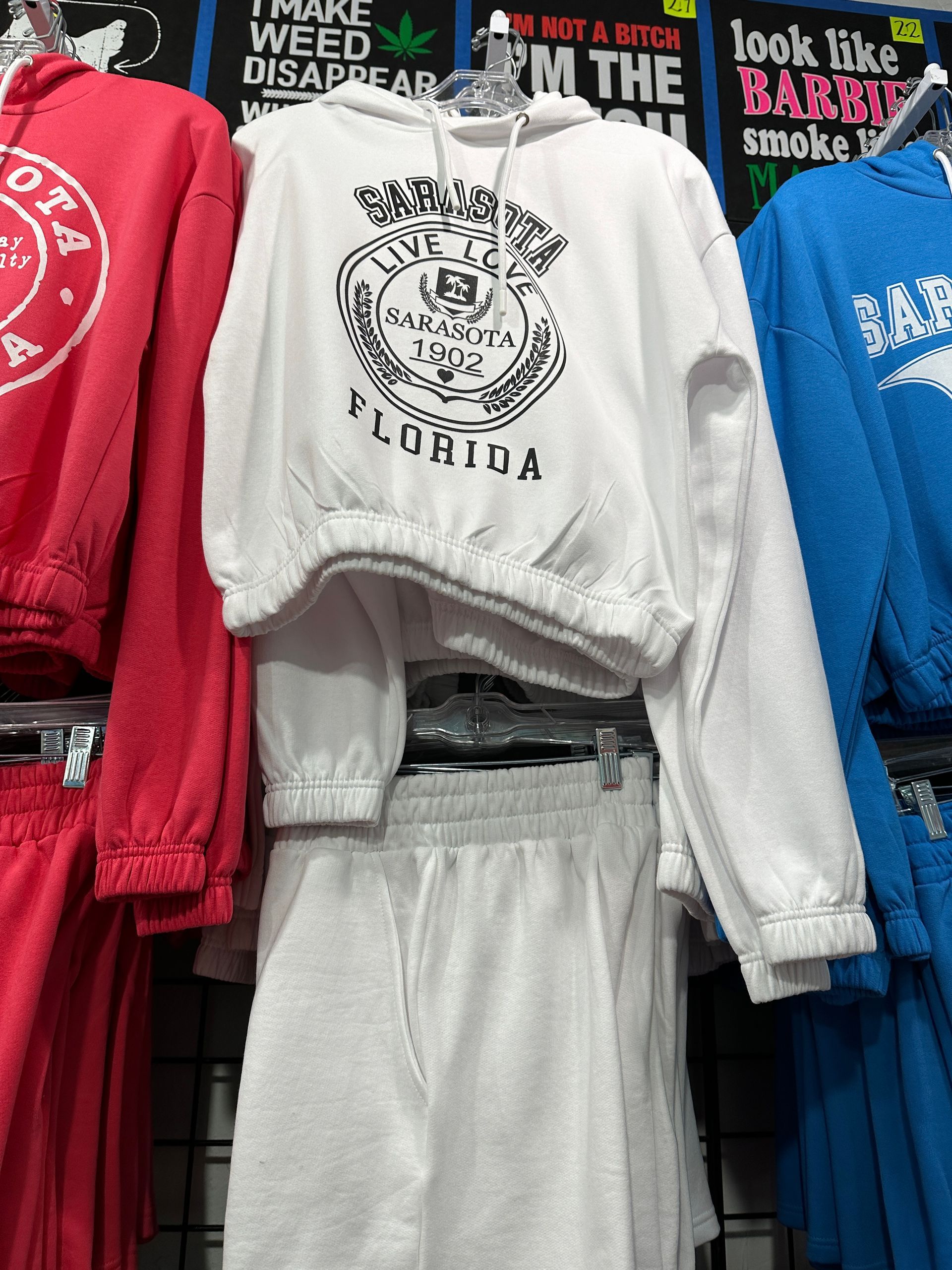 White Florida hoodie and matching skirt on display with other colorful sweatshirts.