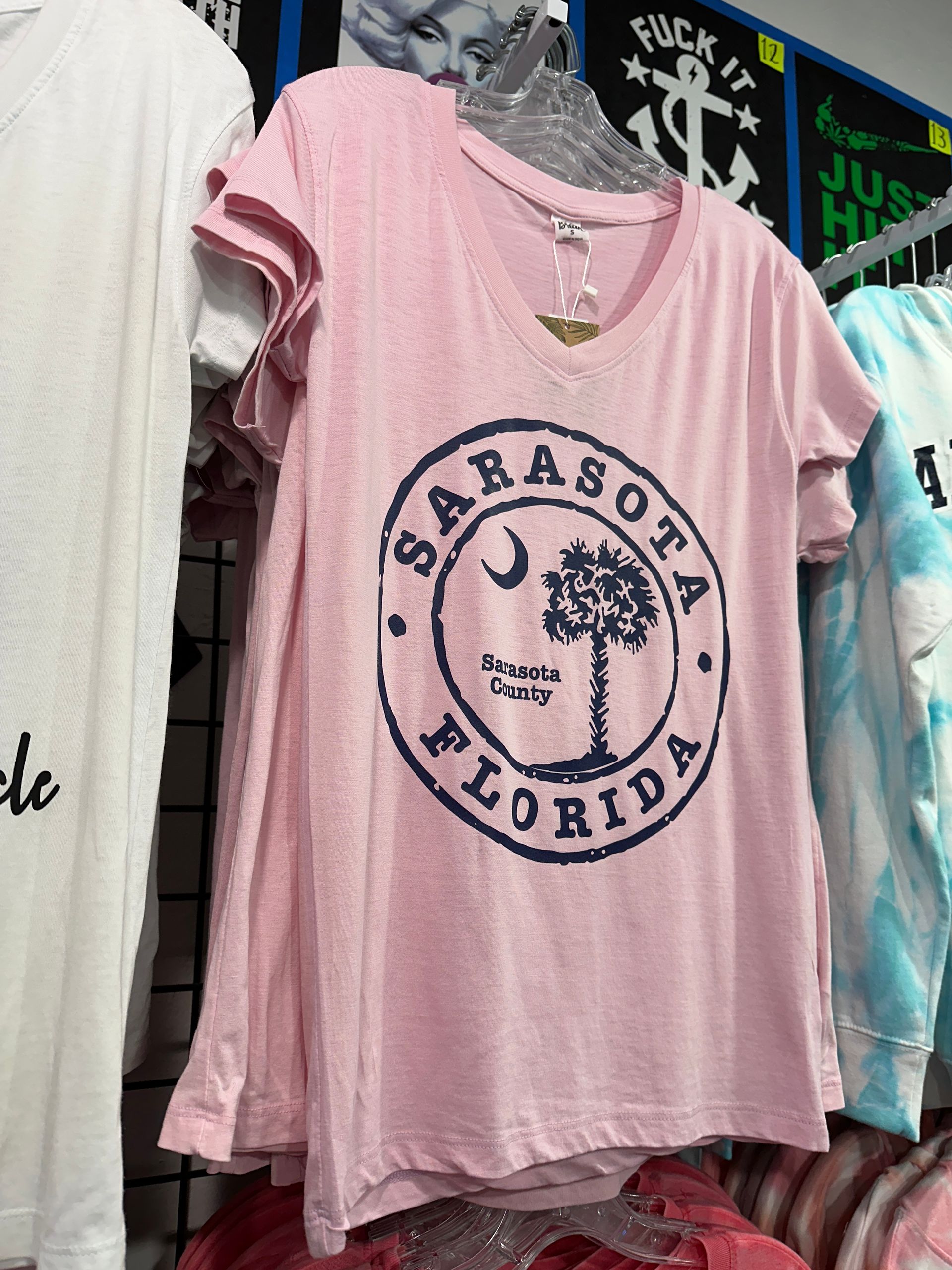 Pink Sarasota Florida t-shirt with a blue circular graphic of a palm tree and crescent moon.