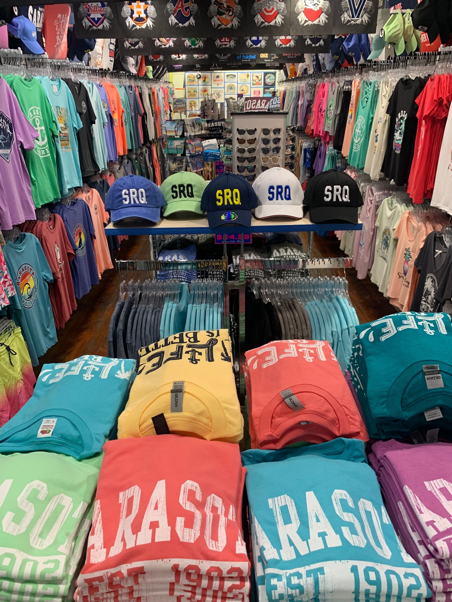 Inside a Sarasota souvenir shop, clothing and hats are displayed for sale.