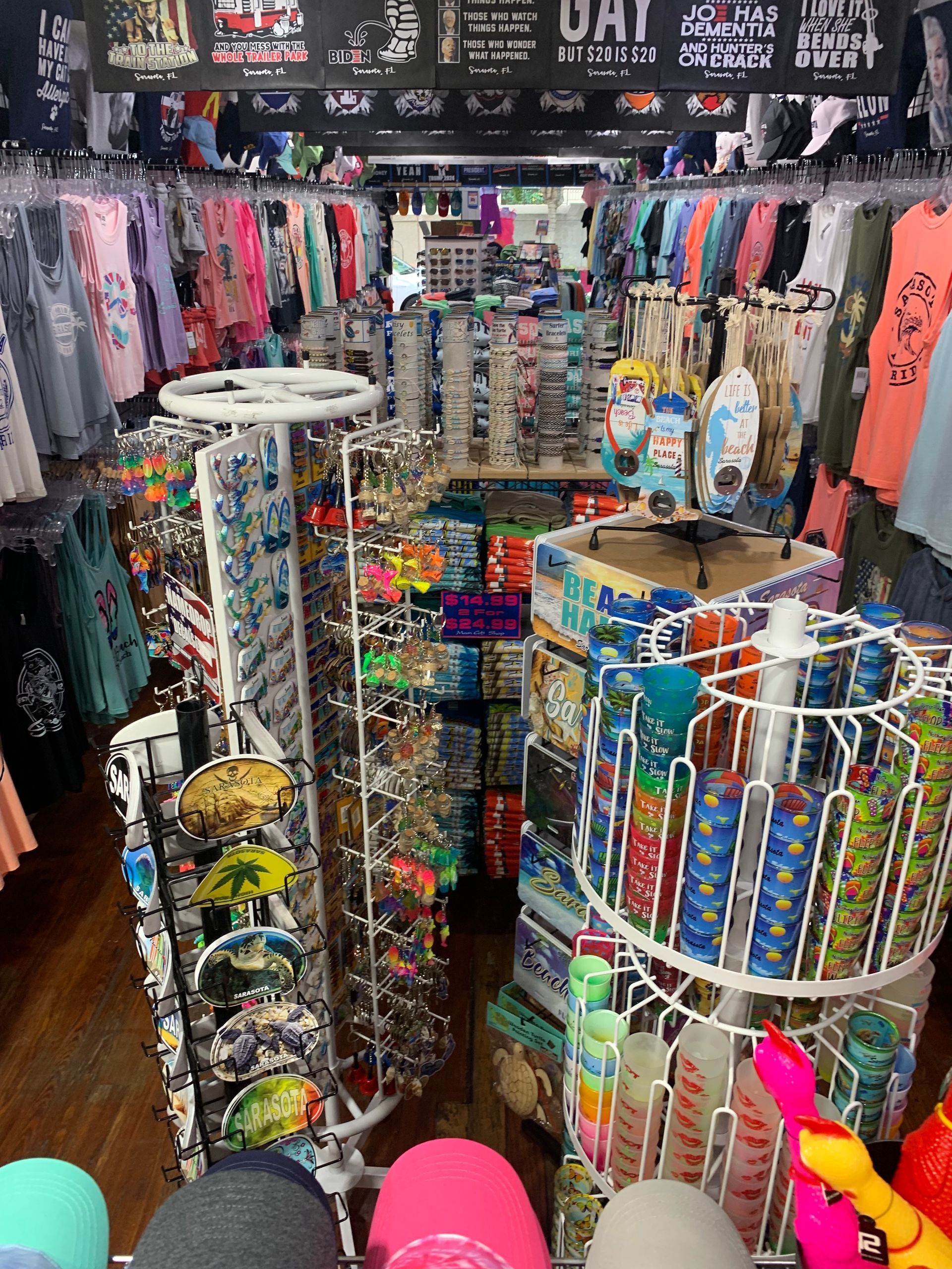 Interior of a brightly lit souvenir shop with clothing racks and various merchandise displays.