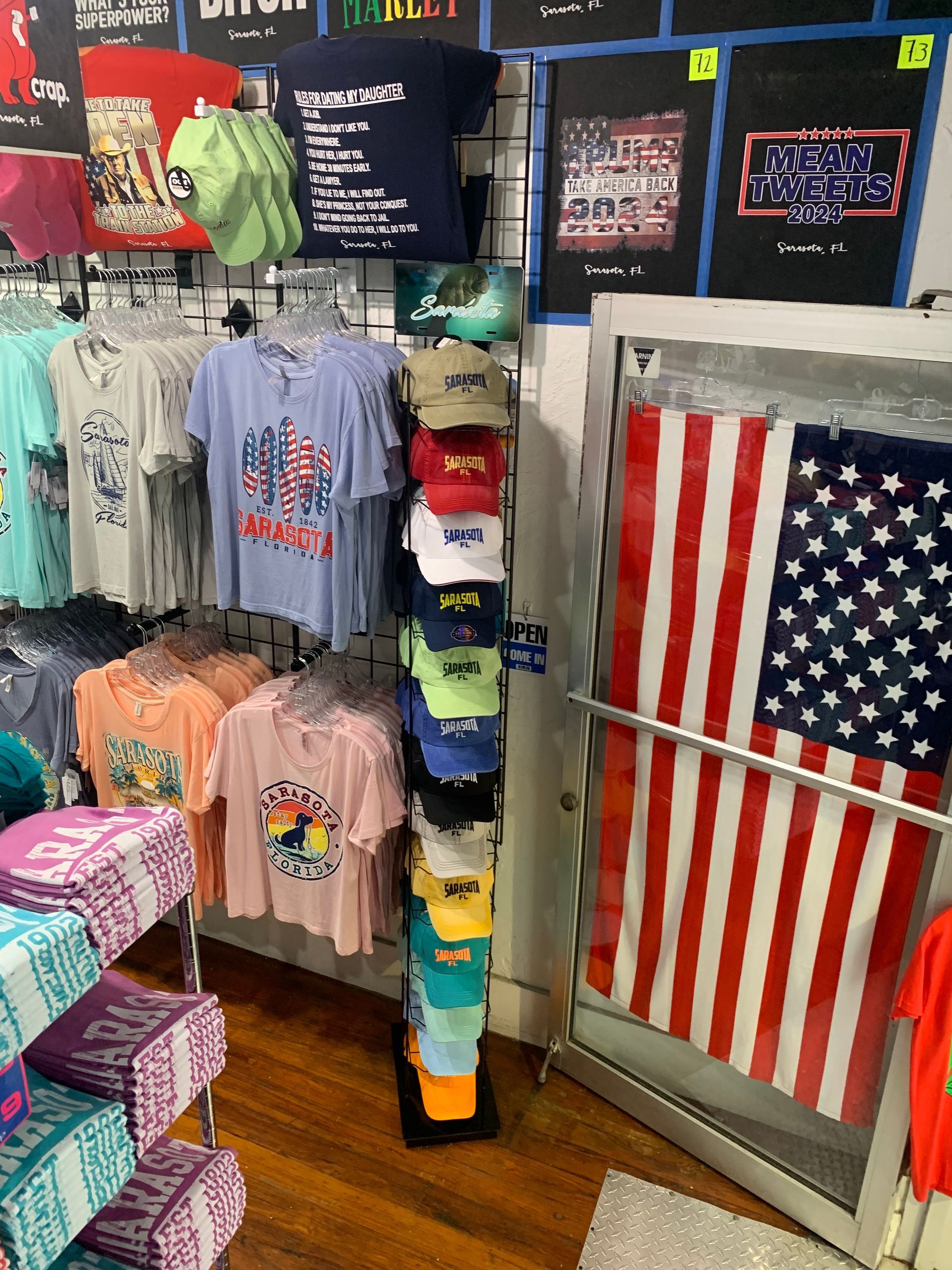 Clothing store display with t-shirts, hats, and an American flag.