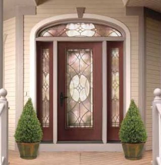 Red front door with glass panels and sidelights, arched transom. Two green potted plants flank the entrance.