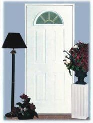 White door with arched glass, flanked by lamp and flower arrangement.