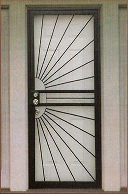 Black metal security door with sunburst design, set in a white door frame.