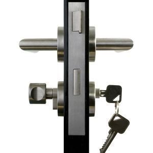 A door with a silver handle and a key in the lock, black background.