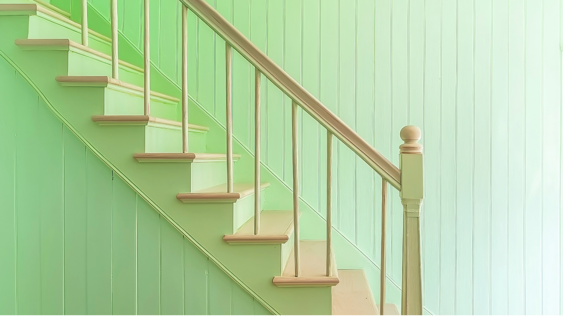 A wooden staircase with a green wall and a white railing.