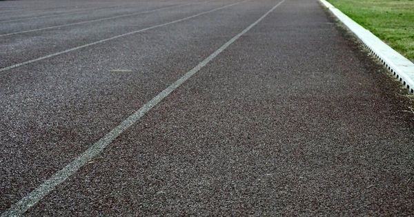 A close up of a running track with a white line on it.