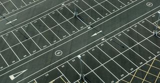 An aerial view of a parking lot with lots of empty parking spaces