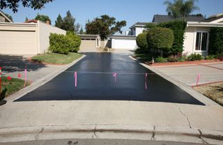 A residential driveway with a pink marker on it