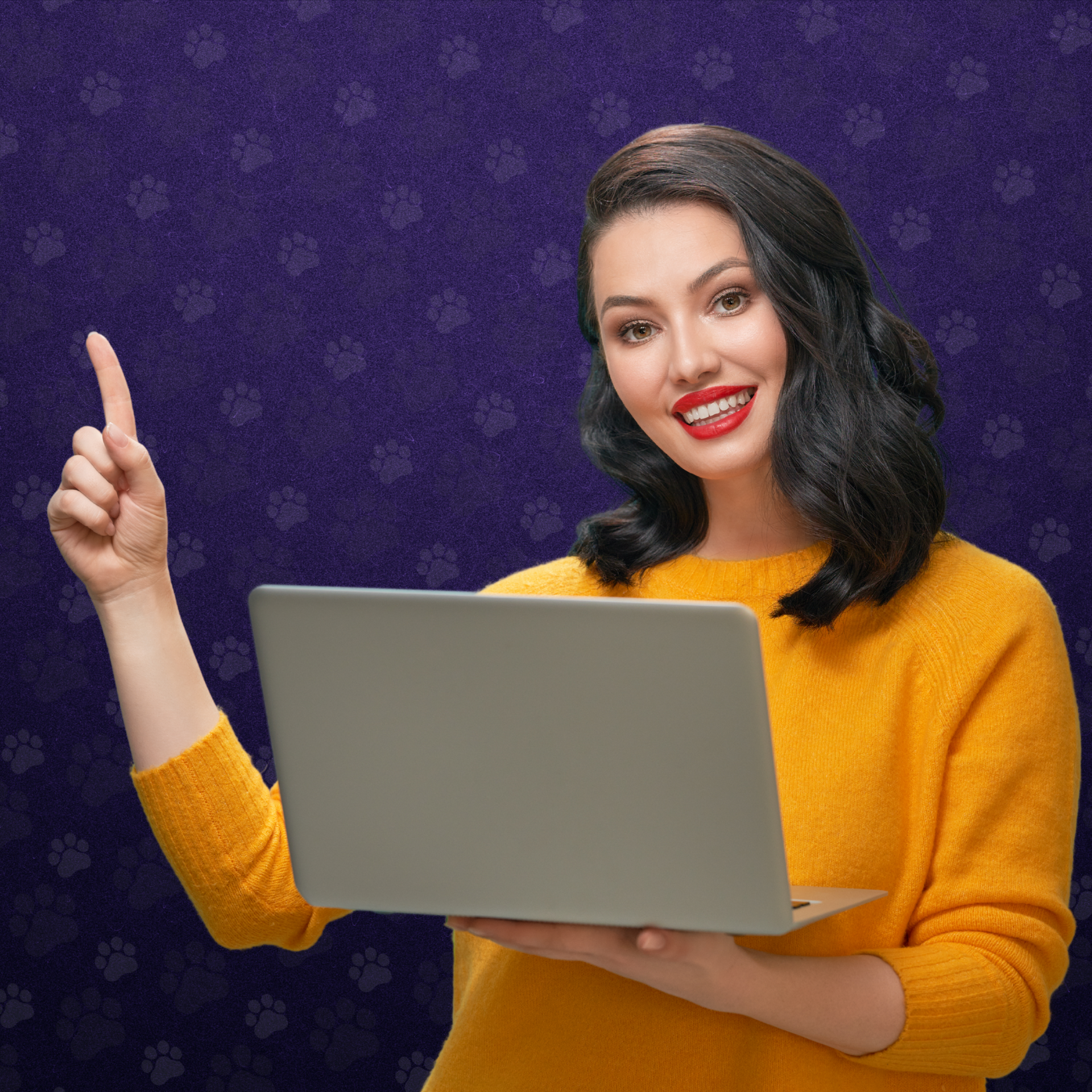 Woman wearing an orange sweater holding a laptop is pointing her index finger up. 