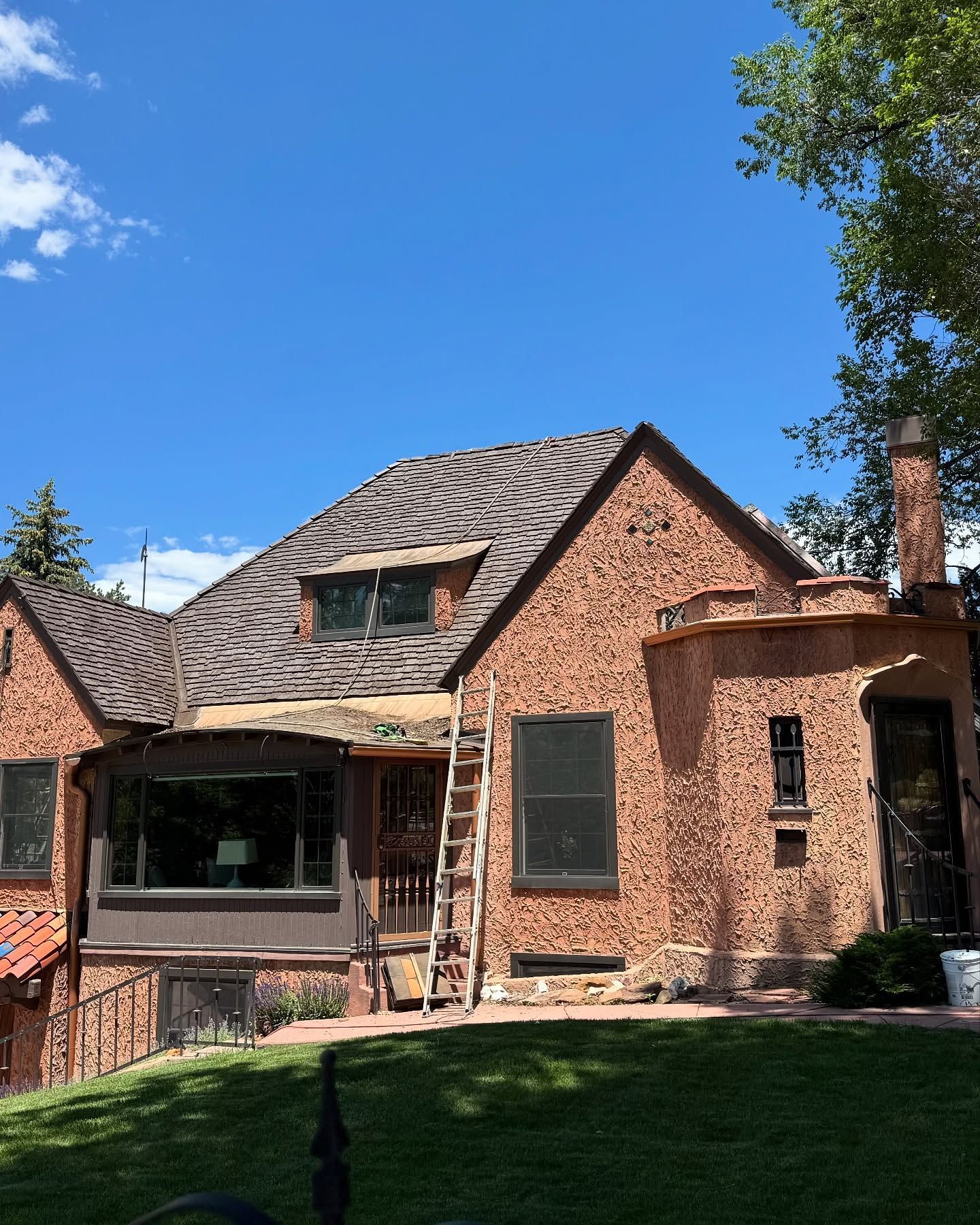 A large brick house with a ladder in front of it.