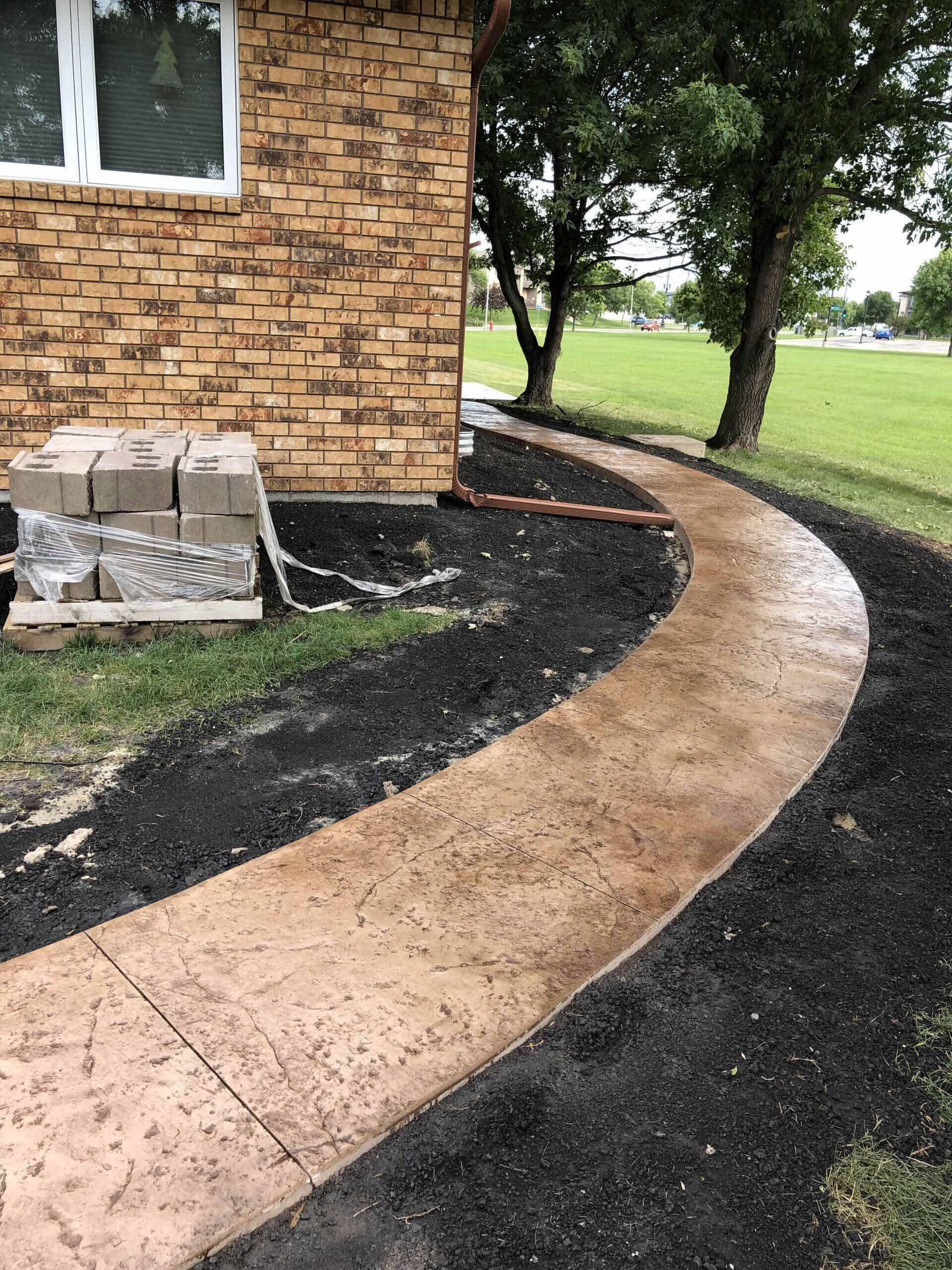 A concrete walkway is being built in front of a house.