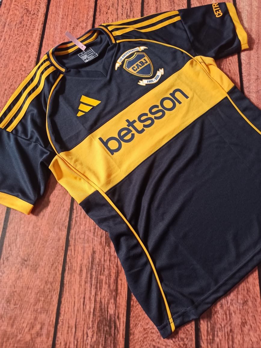 Camiseta de fútbol azul oscuro y dorado con el logotipo de Adidas y el patrocinador