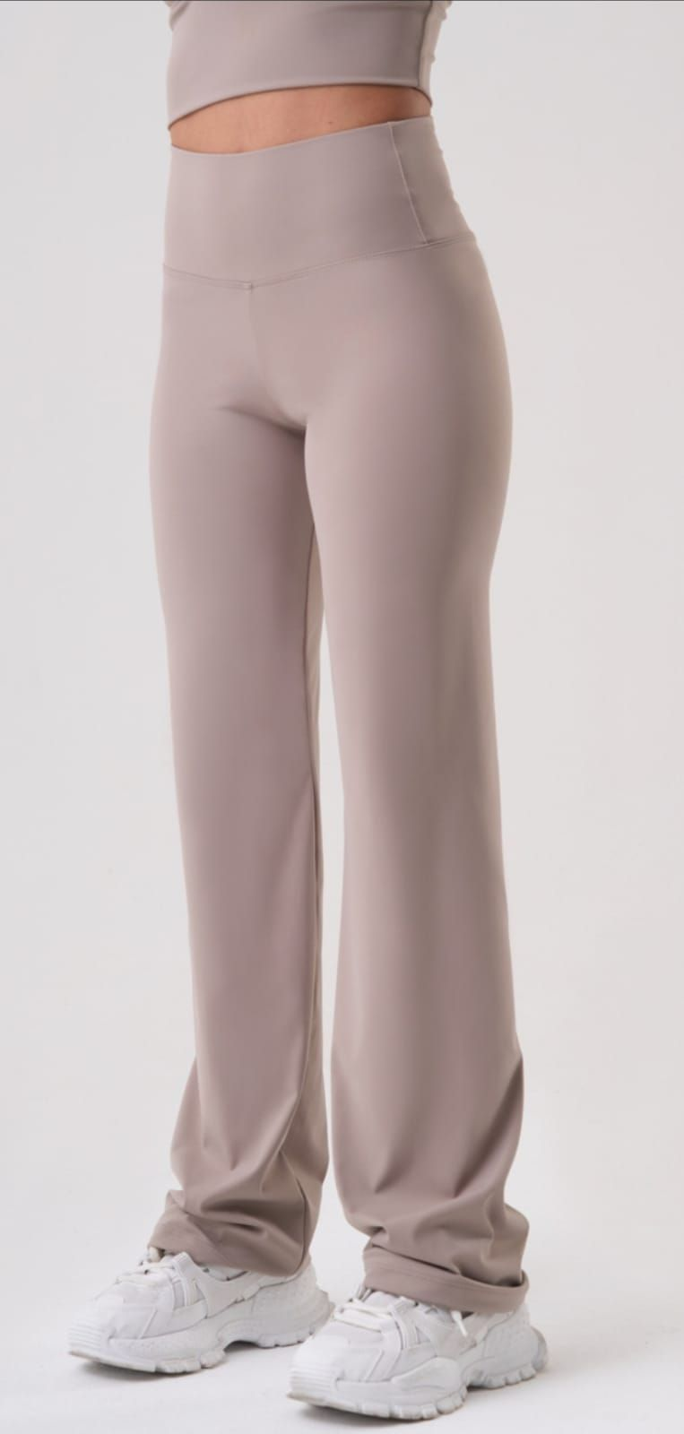 Tres pares de leggings en diferentes tonos de marrón sobre una superficie blanca, con etiquetas de precio.