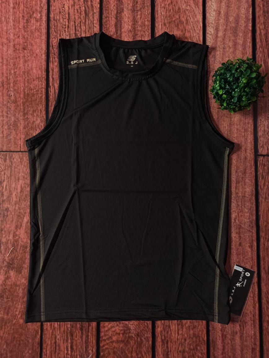 Camiseta deportiva negra sin mangas con detalles dorados, colocada sobre una superficie de madera.