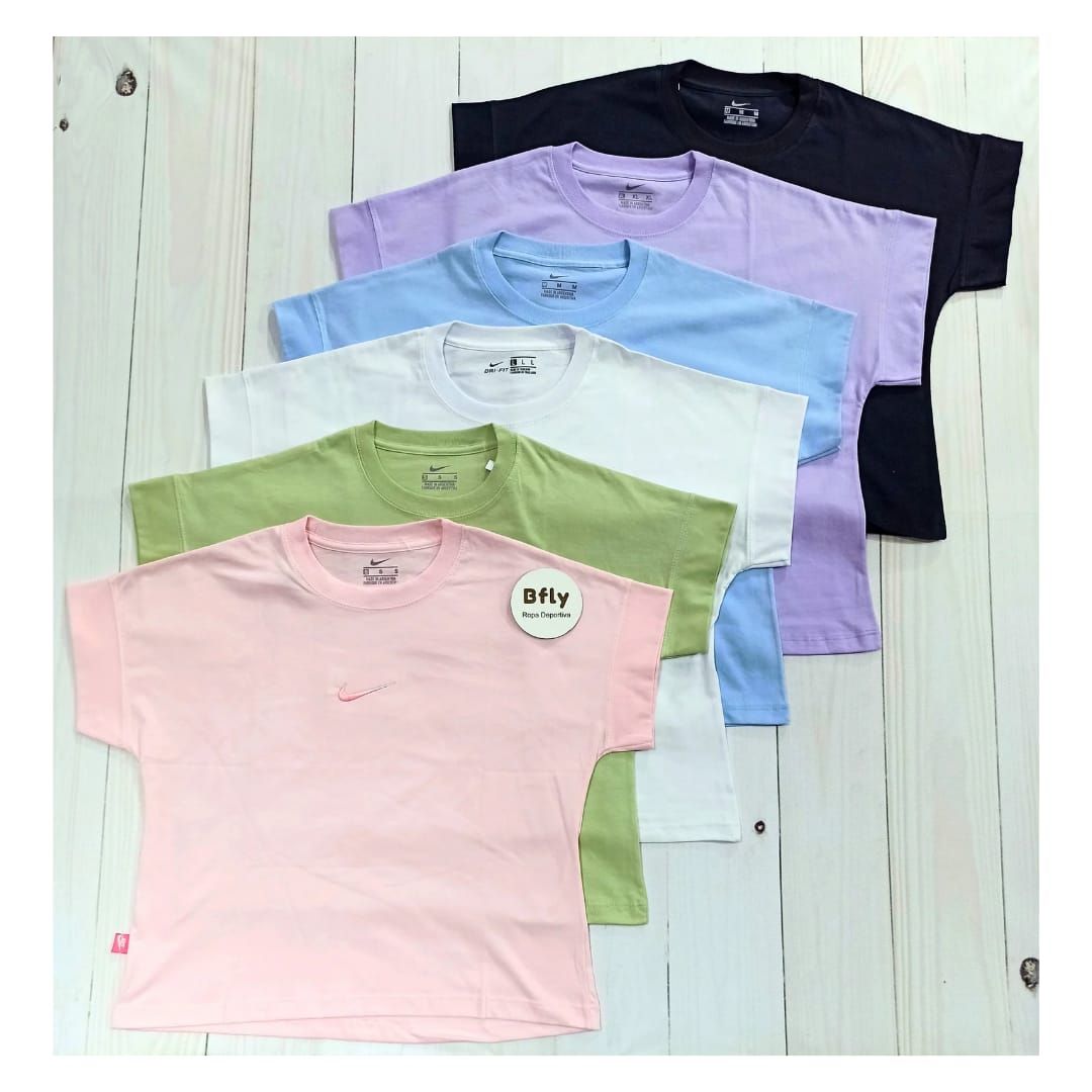 Mujer con un top verde y leggings negros, posando.