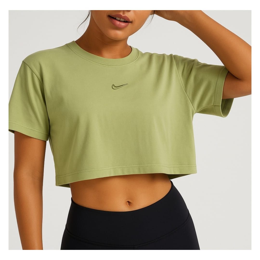 Mujer con un top verde y leggings negros, posando.