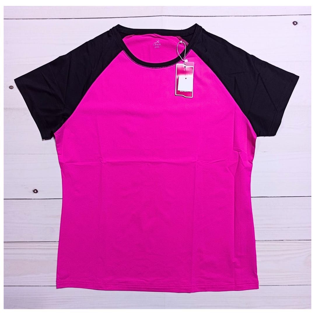 Mujer con camiseta deportiva color magenta y negra y leggings negros caminando por el sendero.