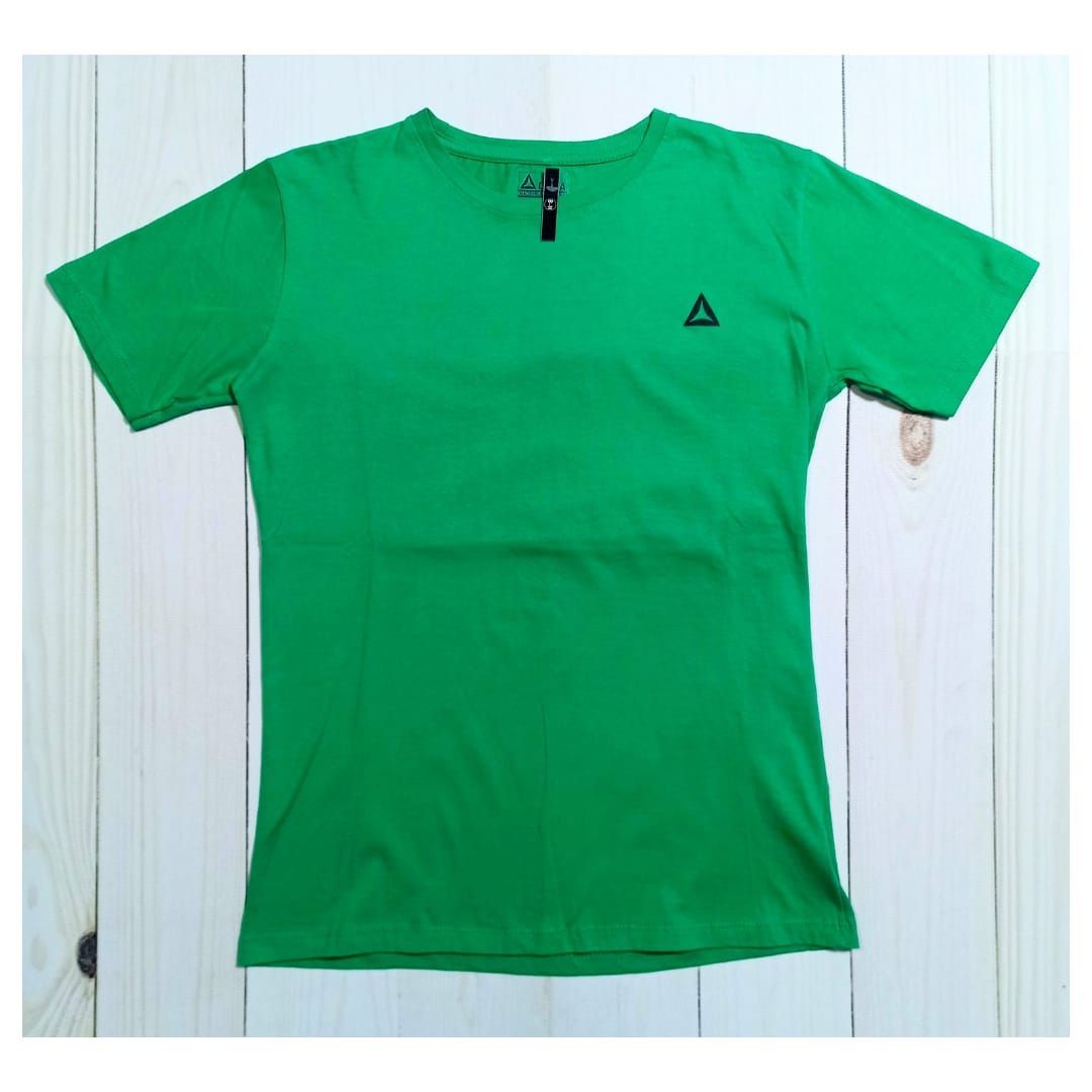 Hombre con camisa verde y pantalones cortos negros sosteniendo mancuernas en un gimnasio.