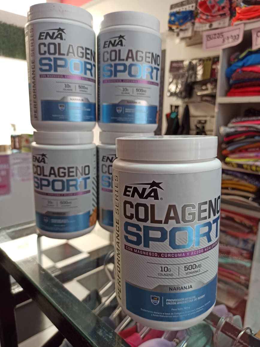 Varios botes blancos del suplemento ENA Colageno Sport, con etiquetas azules y plateadas, expuestos en un estante de cristal.