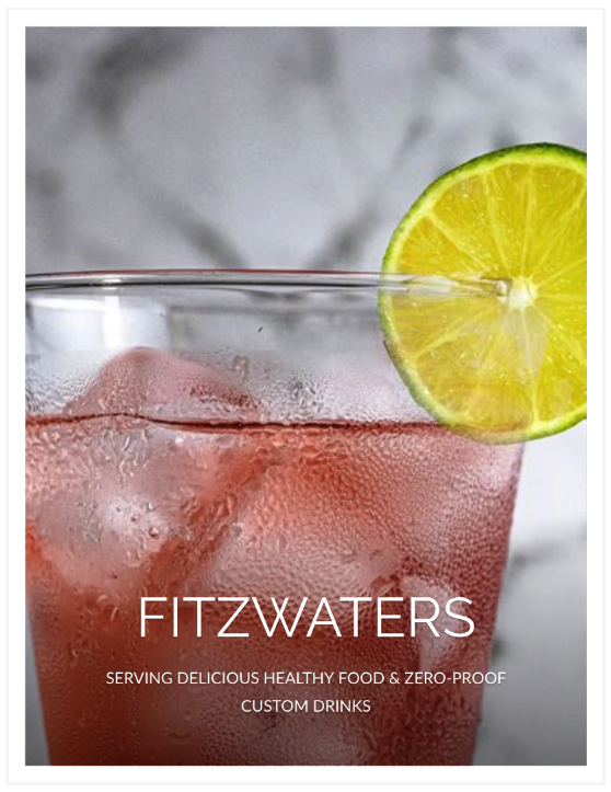 Close-up of a pink drink in a glass with ice and a lime slice, the logo for Fitzwaters.