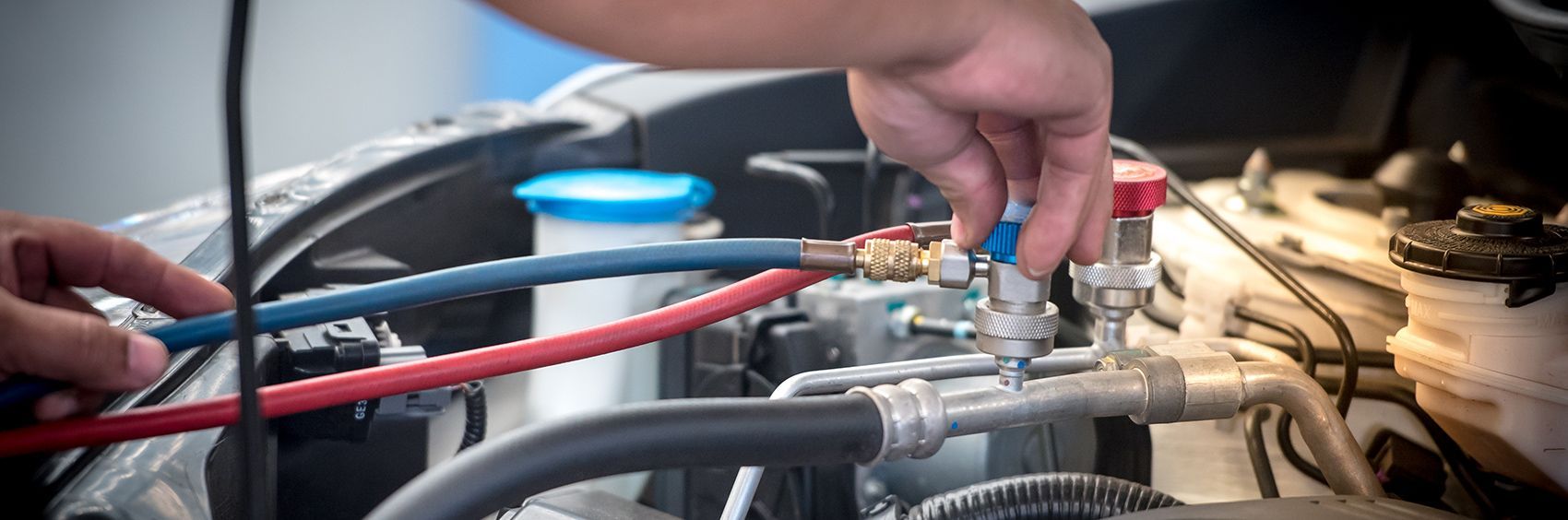 A person is working on the engine of a car.